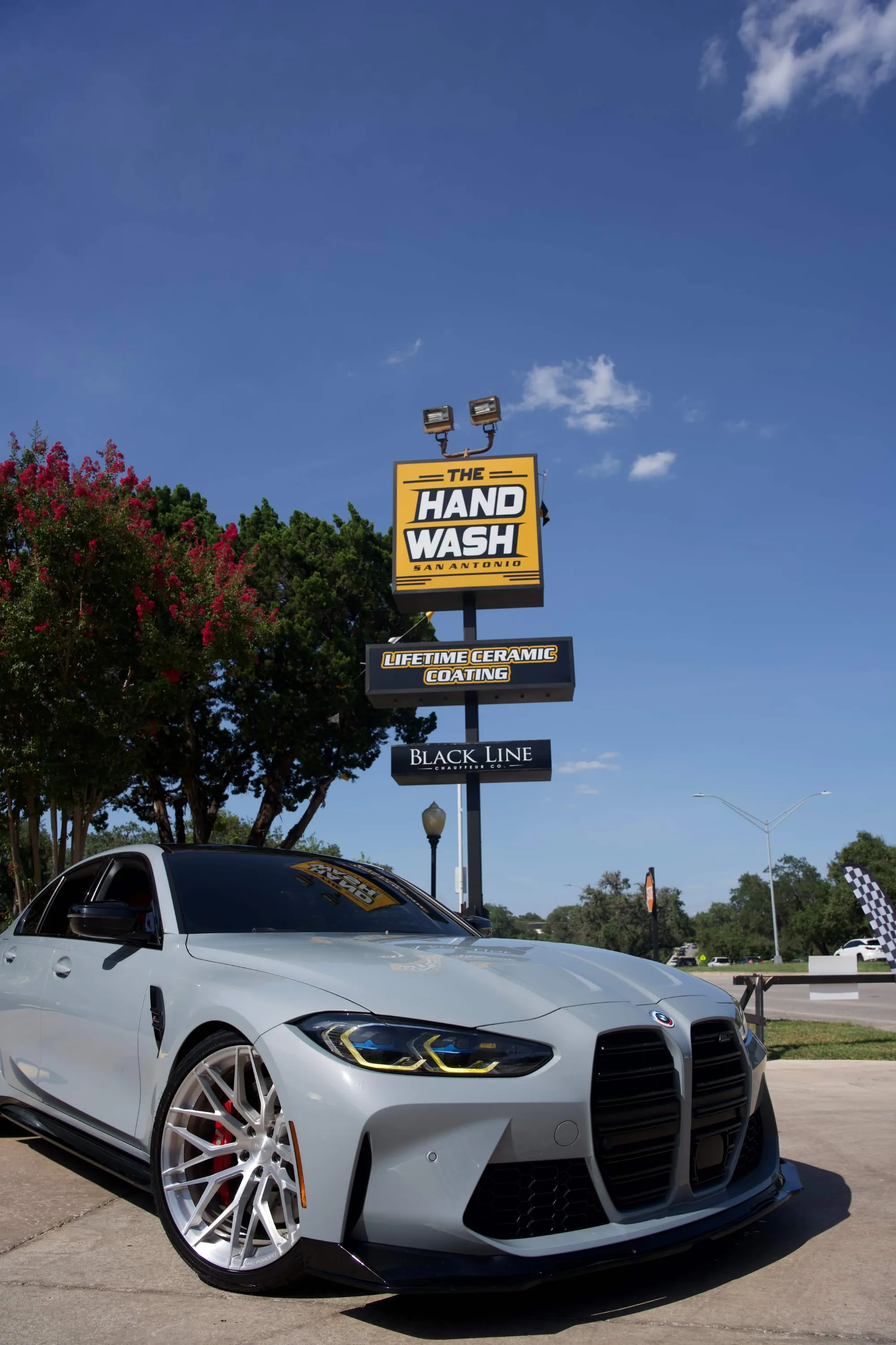 Clean white BMW coupe outside The Hand Wash San Antonio