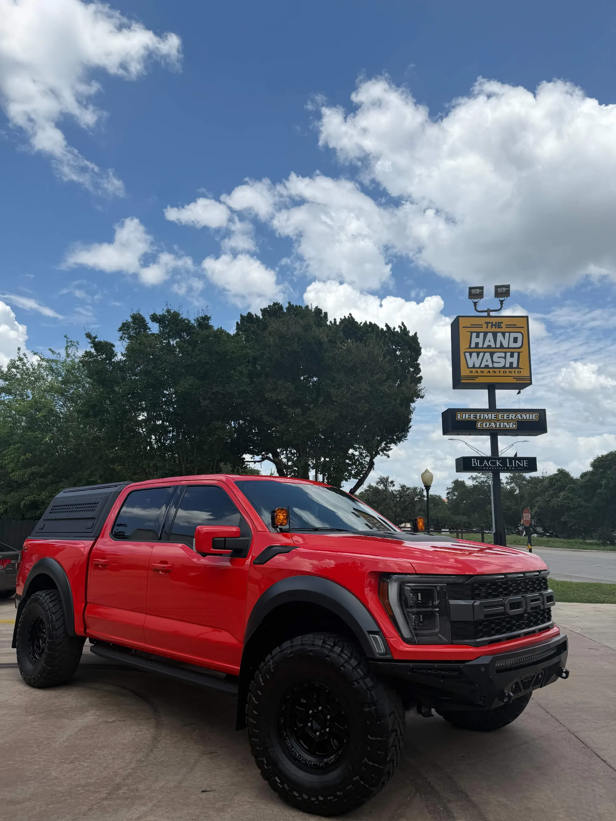 Clean red Ford pickup truck outside The Hand Wash San Antonio