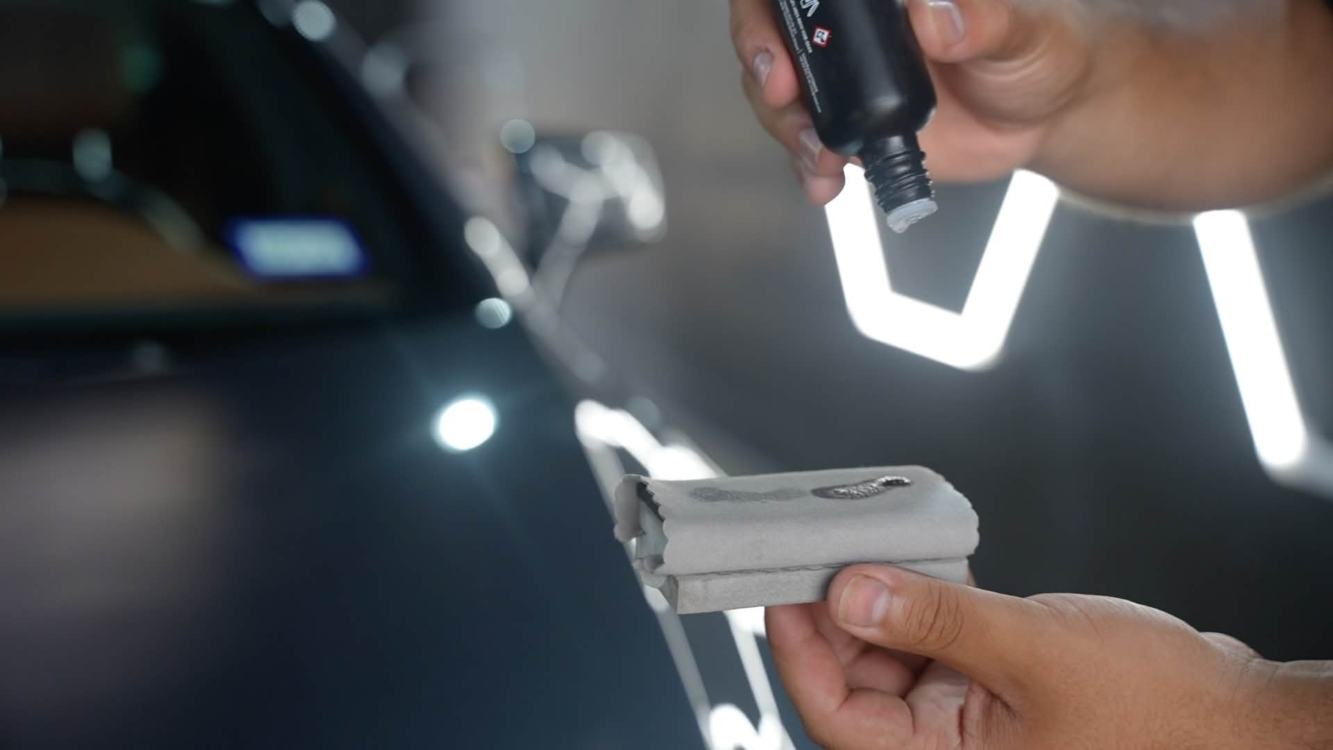 Detailer preparing ceramic coating on an applicator pad
