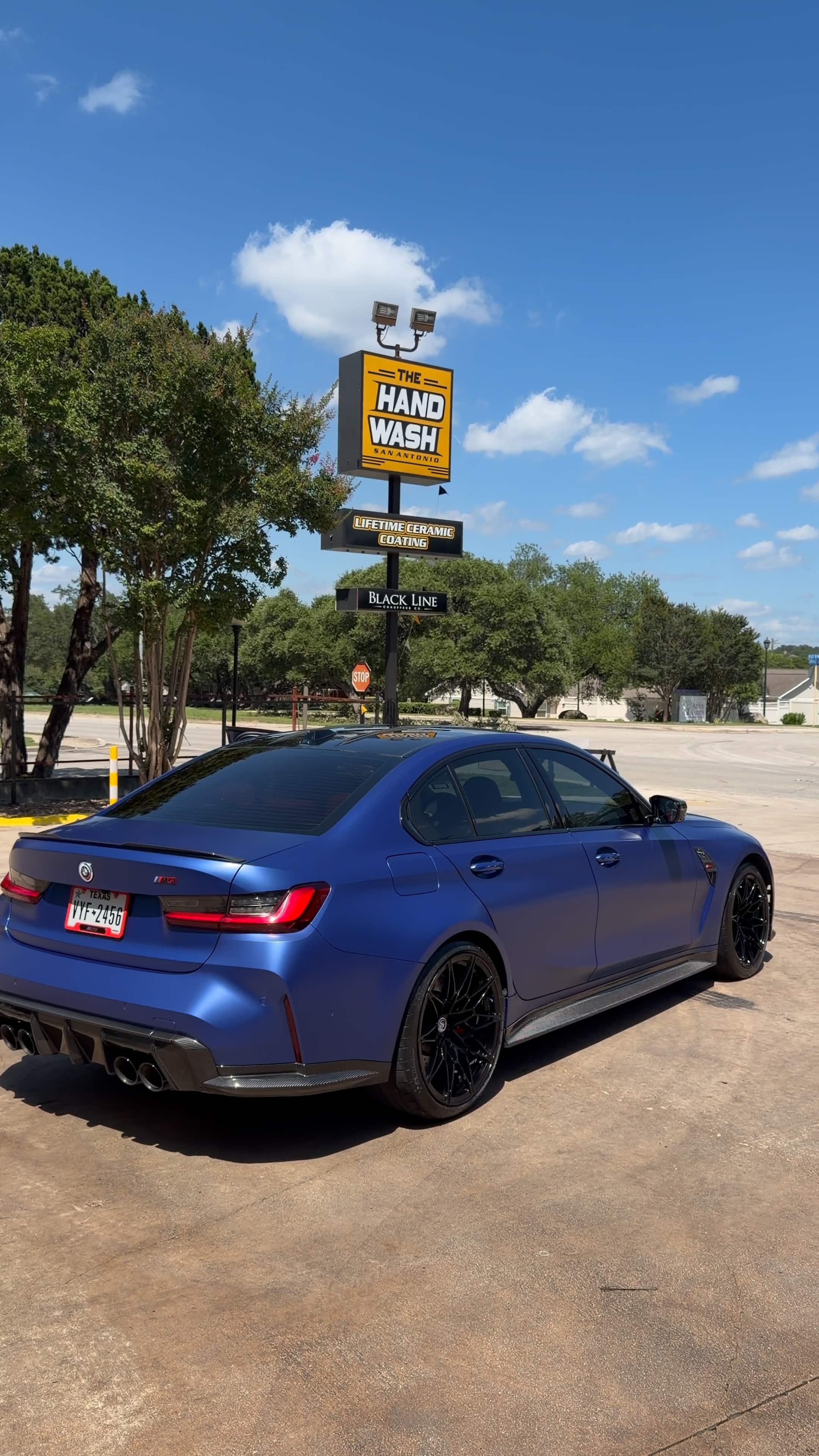 Clean blue BMW sedan outside The Hand Wash San Antonio